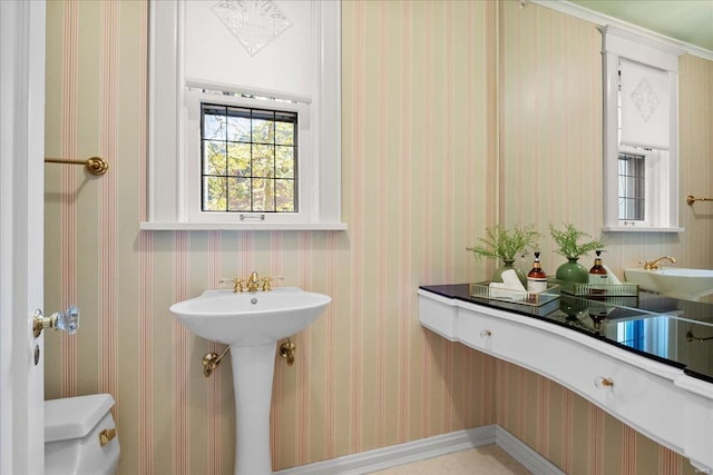 bathroom with a sink and wallpapered walls