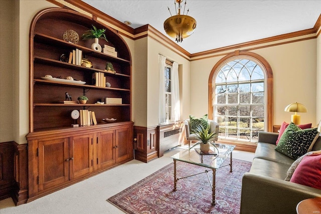 living area featuring ornamental molding, wainscoting, a wealth of natural light, and light colored carpet