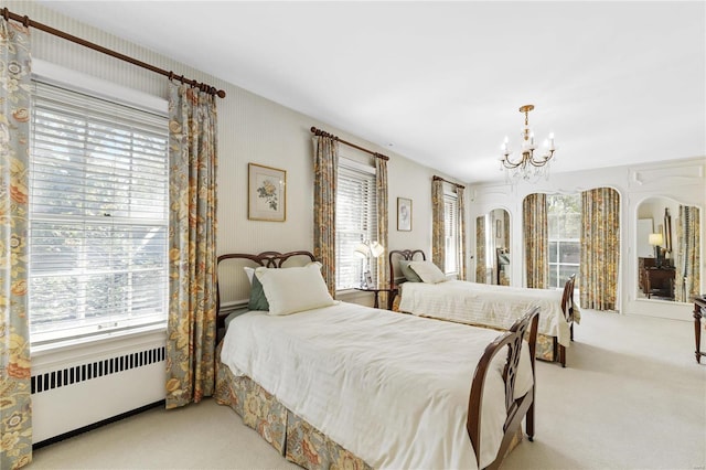 bedroom featuring carpet floors, radiator heating unit, and a notable chandelier