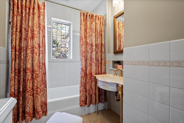 bathroom with tile patterned flooring, tile walls, and shower / tub combo