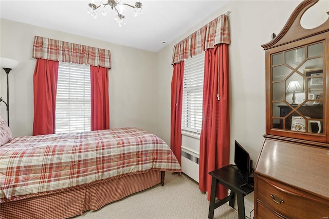 carpeted bedroom featuring a notable chandelier and radiator