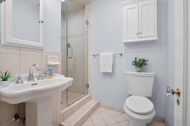 full bathroom with tile patterned flooring, a shower stall, toilet, and baseboards