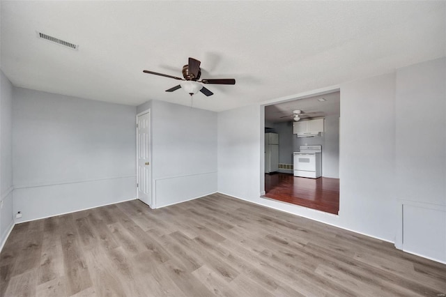 spare room with ceiling fan, visible vents, and wood finished floors