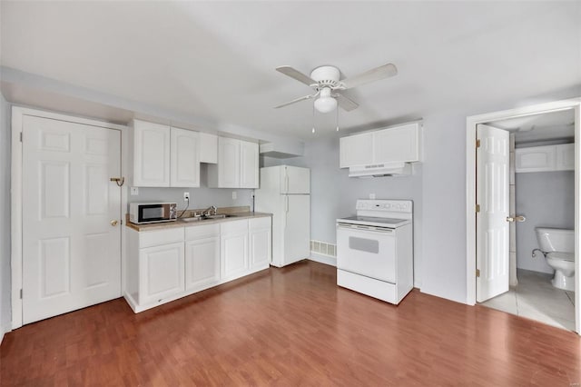 kitchen featuring light countertops, white appliances, wood finished floors, and under cabinet range hood