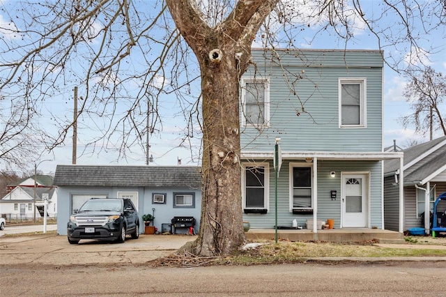 view of front of property featuring a porch, a shingled roof, and driveway