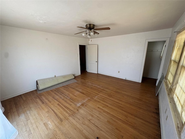 spare room with ceiling fan, baseboards, and hardwood / wood-style floors