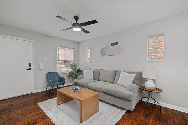 living area featuring a ceiling fan, baseboards, and wood finished floors