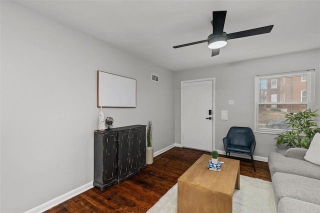 living room featuring visible vents, baseboards, and wood finished floors