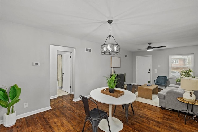 dining space with dark wood-style flooring, visible vents, and baseboards