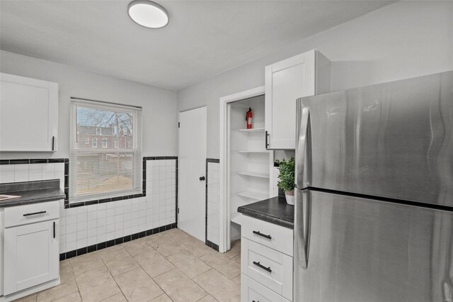 kitchen with dark countertops, white cabinets, open shelves, and freestanding refrigerator