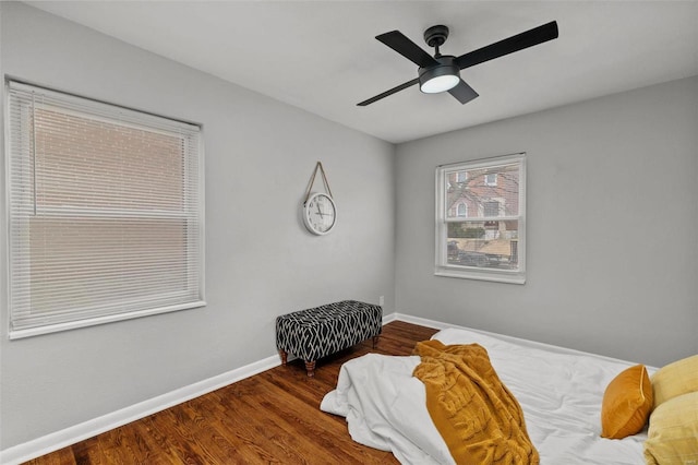 bedroom with wood finished floors, a ceiling fan, and baseboards