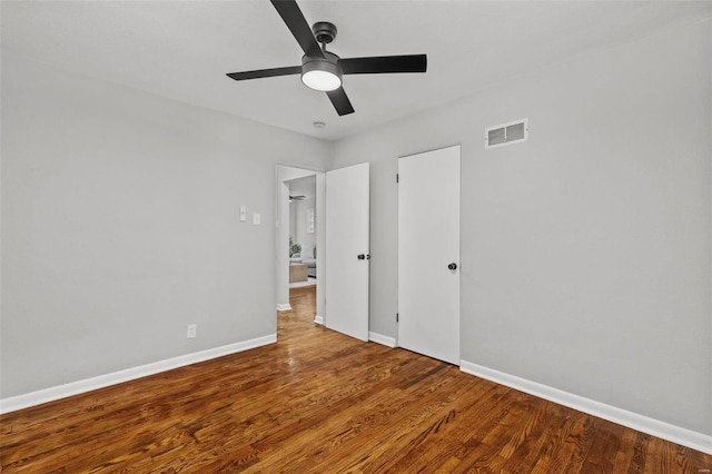 unfurnished bedroom with a ceiling fan, wood finished floors, visible vents, and baseboards