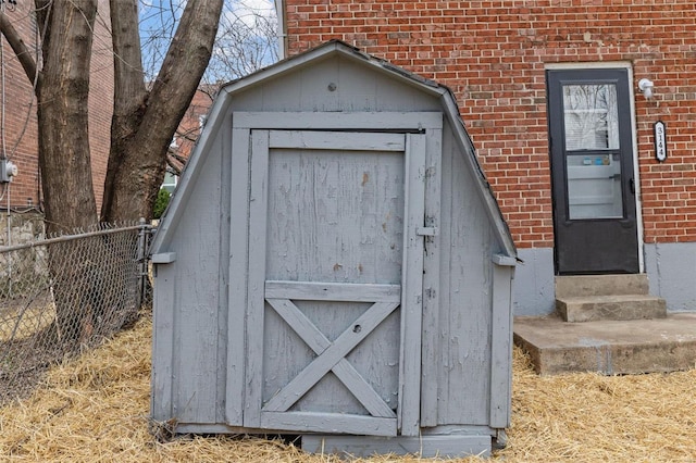 view of outdoor structure with entry steps and fence