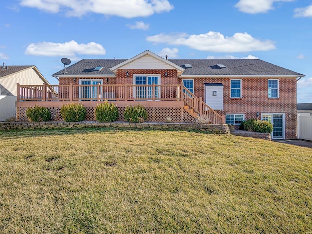 view of front of house with a wooden deck, a front lawn, and brick siding