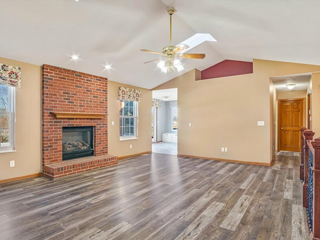 unfurnished living room featuring ceiling fan, lofted ceiling, a fireplace, and wood finished floors