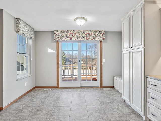 unfurnished dining area with baseboards