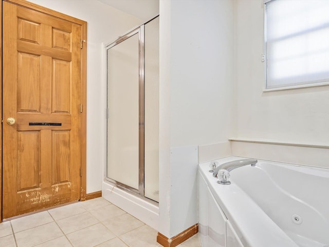 bathroom with baseboards, a stall shower, a jetted tub, and tile patterned floors