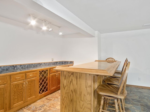 bar featuring indoor bar, stone finish floor, visible vents, and baseboards