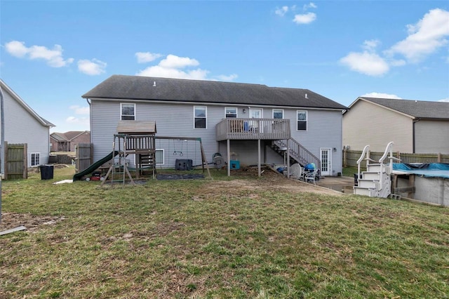 back of property featuring fence, a wooden deck, stairs, central AC, and a lawn