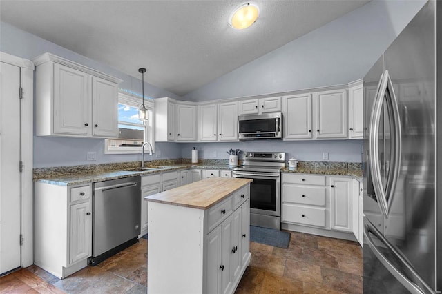 kitchen with wood counters, white cabinets, appliances with stainless steel finishes, and a sink