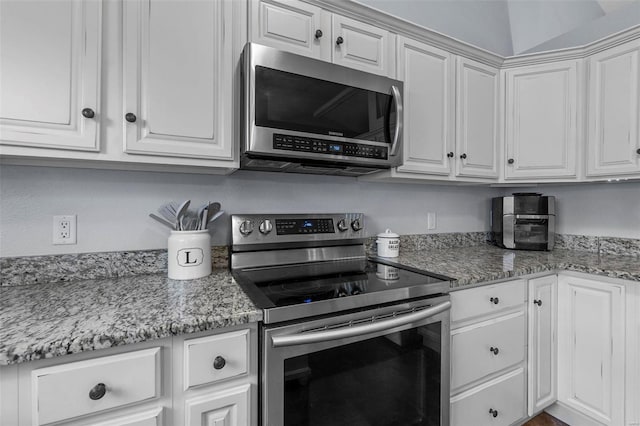 kitchen with appliances with stainless steel finishes, white cabinetry, and light stone countertops