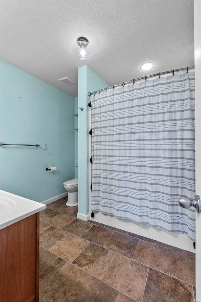 full bathroom featuring visible vents, toilet, stone tile flooring, vanity, and shower / bathtub combination with curtain