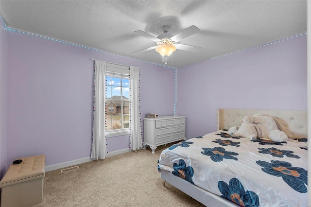 carpeted bedroom with visible vents, baseboards, a textured ceiling, and a ceiling fan