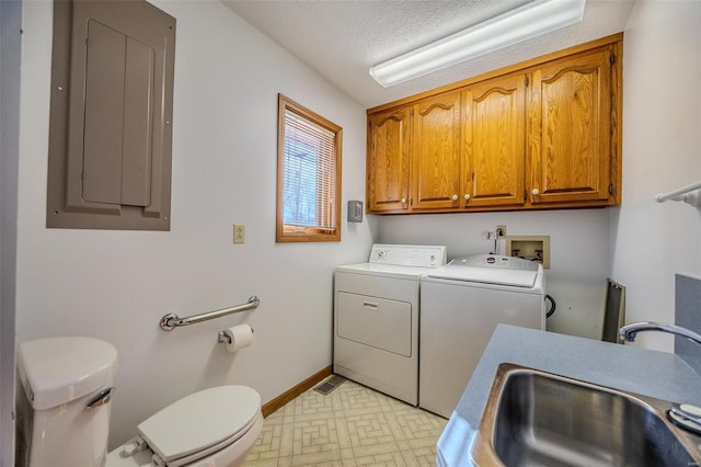 clothes washing area with a textured ceiling, a sink, baseboards, electric panel, and washer and clothes dryer