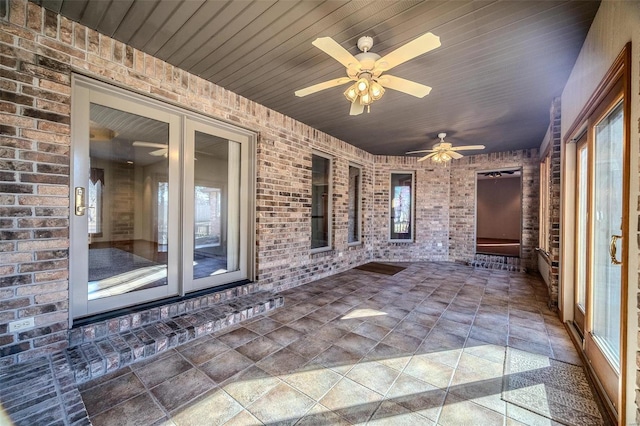 unfurnished sunroom with wooden ceiling and ceiling fan