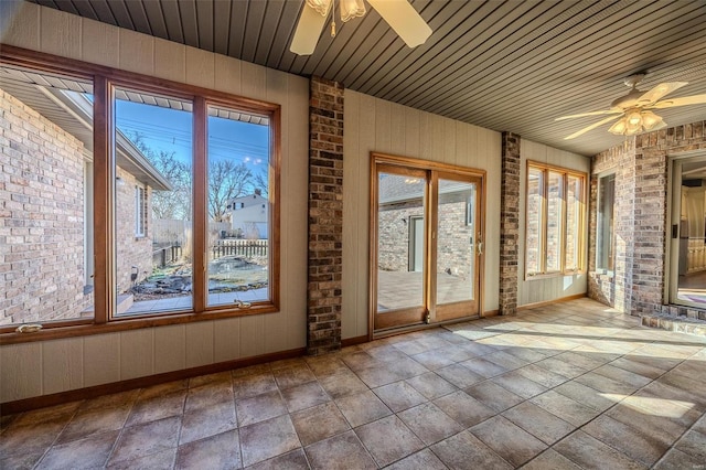 unfurnished sunroom with wooden ceiling, ceiling fan, and a wealth of natural light