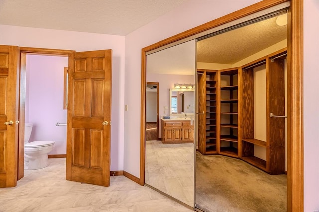 full bath featuring toilet, baseboards, a textured ceiling, and vanity