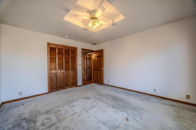 unfurnished bedroom featuring a textured ceiling, a closet, carpet, and baseboards