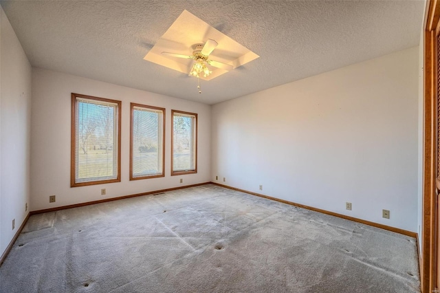 unfurnished room featuring ceiling fan, a textured ceiling, baseboards, and light colored carpet