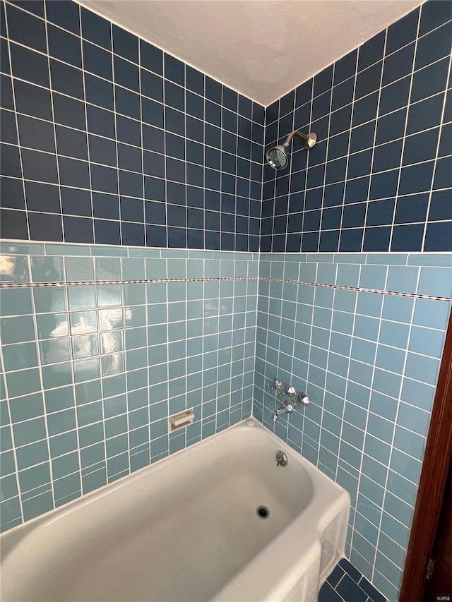 bathroom with tile patterned flooring and washtub / shower combination