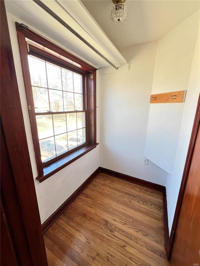 unfurnished room with baseboards and wood finished floors