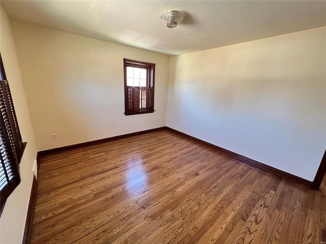 unfurnished room with baseboards and wood finished floors