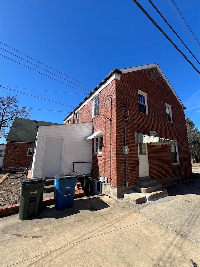 view of home's exterior with entry steps and brick siding