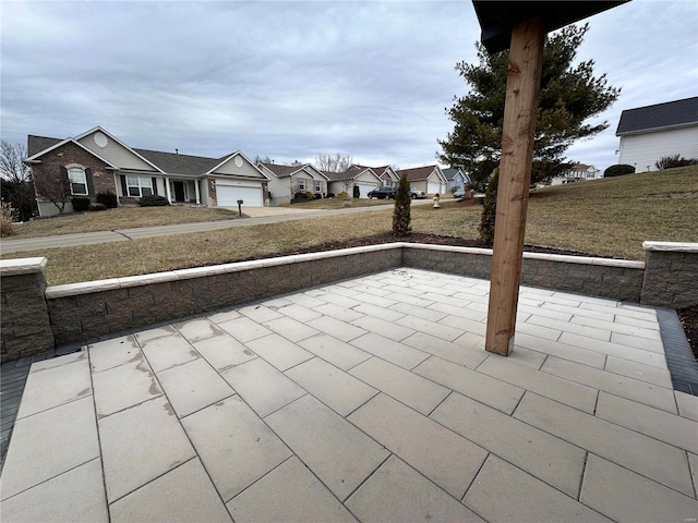 view of patio / terrace with a garage and a residential view