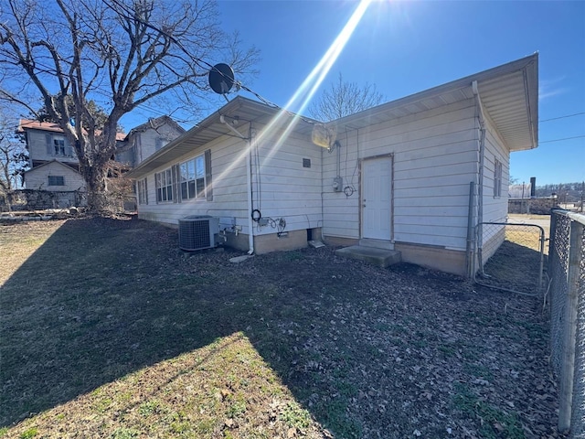 back of house with entry steps, a yard, cooling unit, and fence