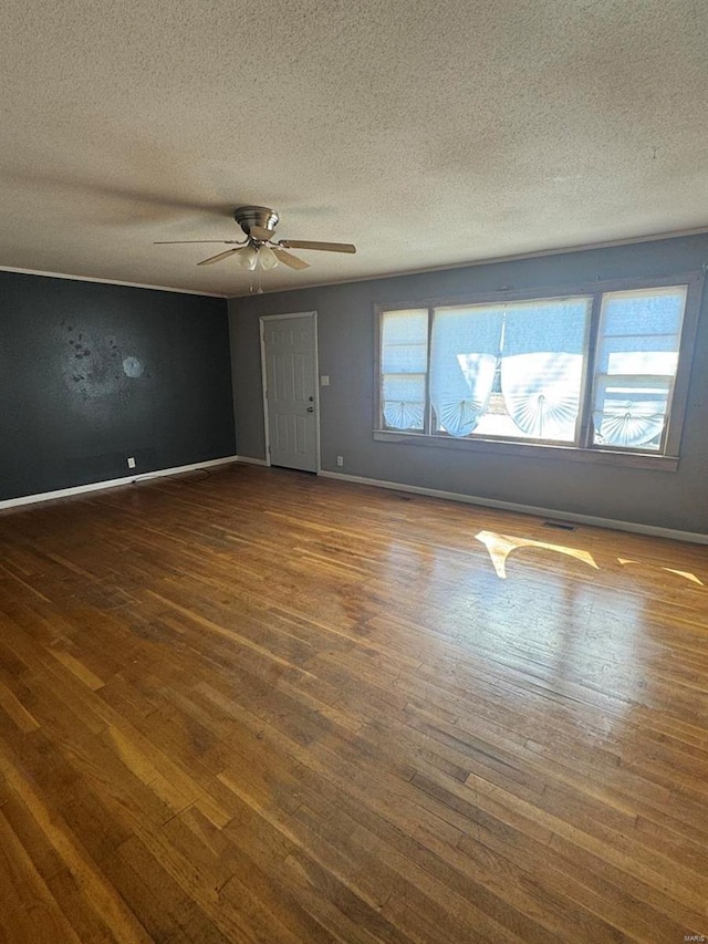 unfurnished room featuring dark wood-style floors, a textured ceiling, and baseboards