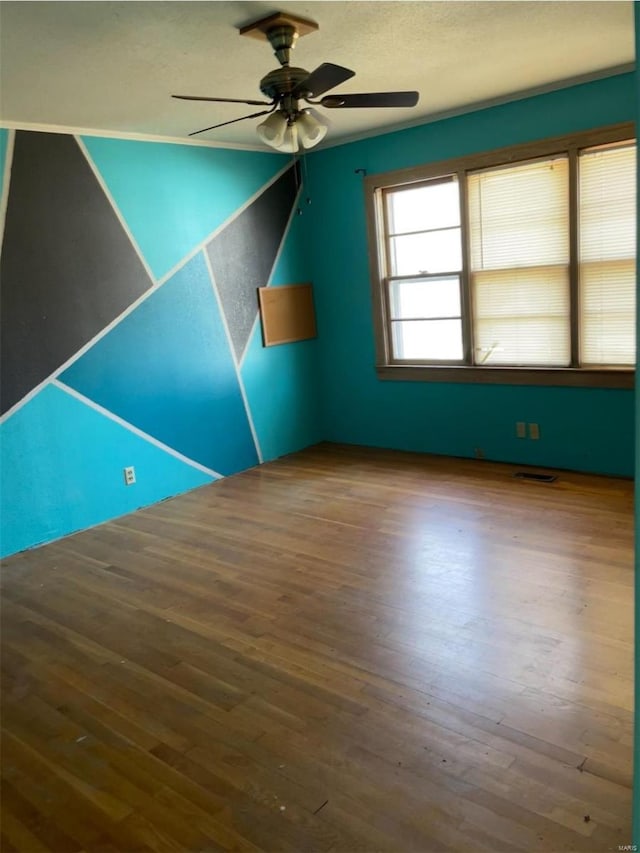 unfurnished room with a ceiling fan, visible vents, a textured ceiling, and wood finished floors