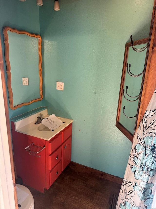 bathroom with visible vents, vanity, toilet, and wood finished floors