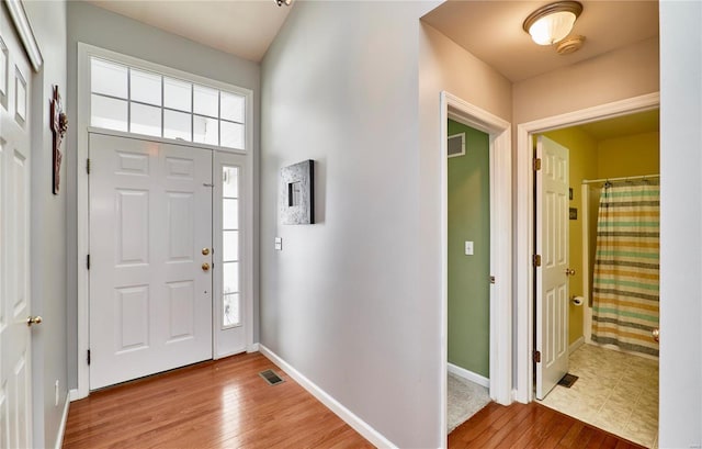 entryway with light wood-style flooring, visible vents, and baseboards