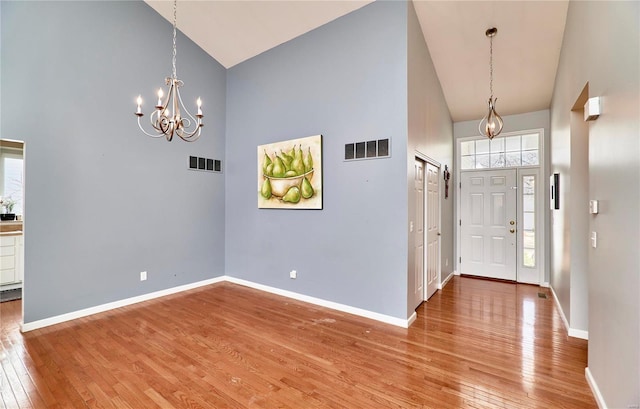 entrance foyer with high vaulted ceiling, wood-type flooring, and visible vents