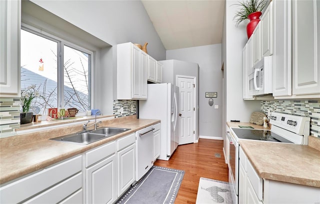 kitchen featuring a sink, white appliances, white cabinets, and light countertops