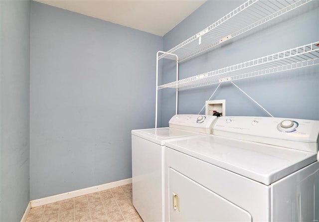 clothes washing area with laundry area, baseboards, and washer and dryer