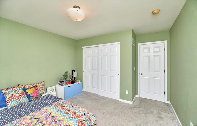 bedroom featuring baseboards, a closet, and light colored carpet