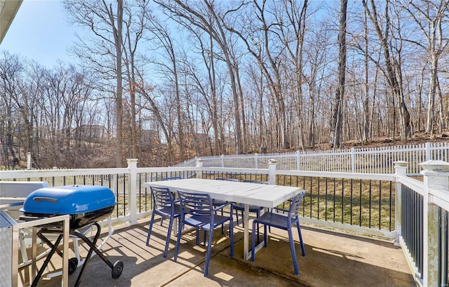 wooden terrace with outdoor dining space, fence, and grilling area