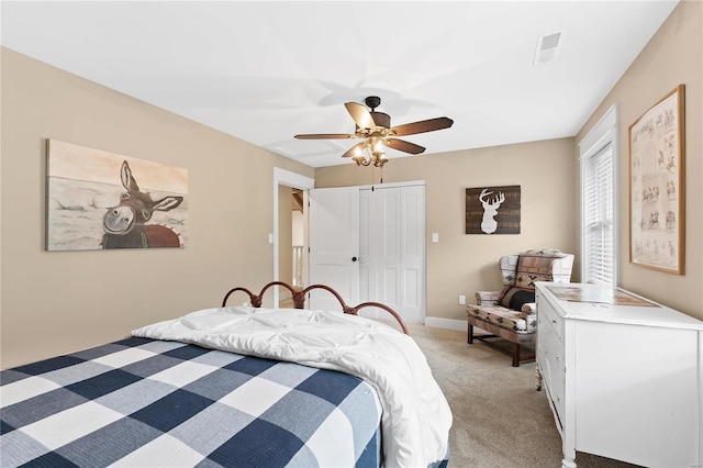 bedroom featuring light carpet, a ceiling fan, visible vents, baseboards, and a closet