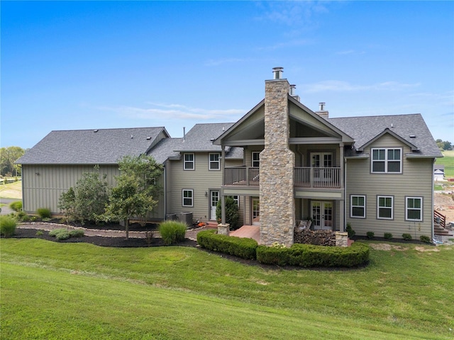 back of property with french doors, a yard, a balcony, and a patio